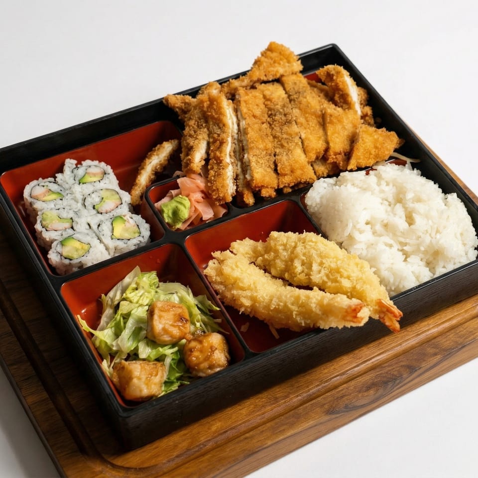 Bento box with chicken katsu, sushi, tempura shrimp, rice, salad, and pickled ginger.